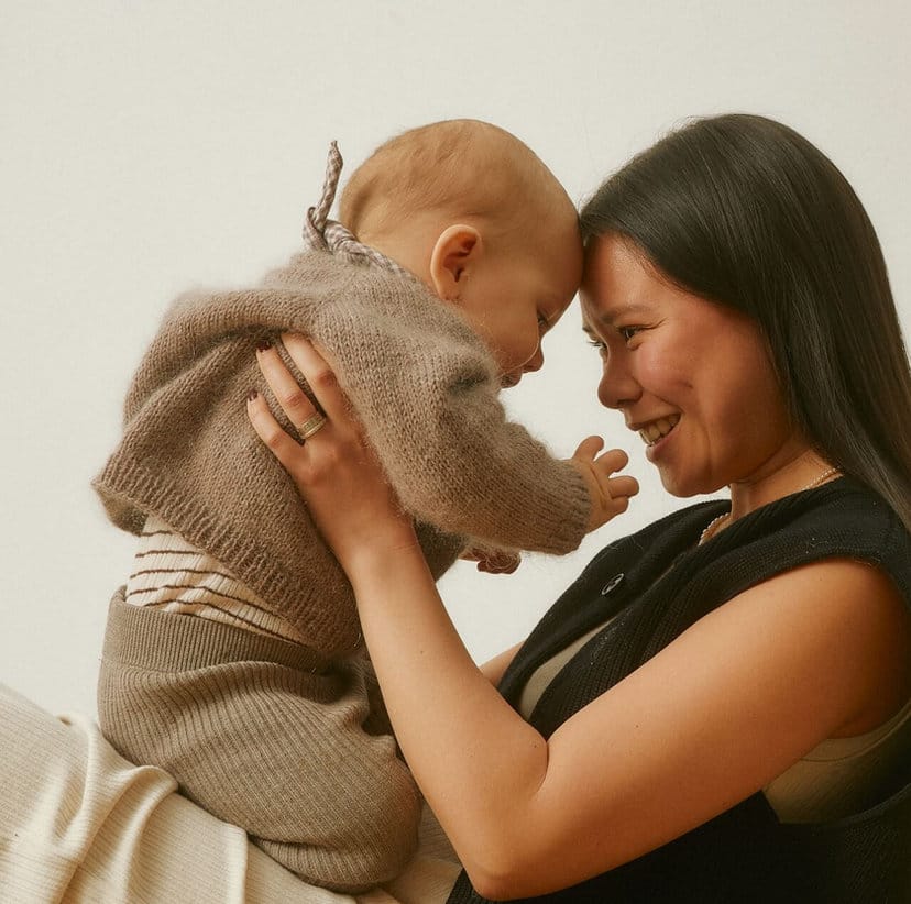 A mother lifting her baby